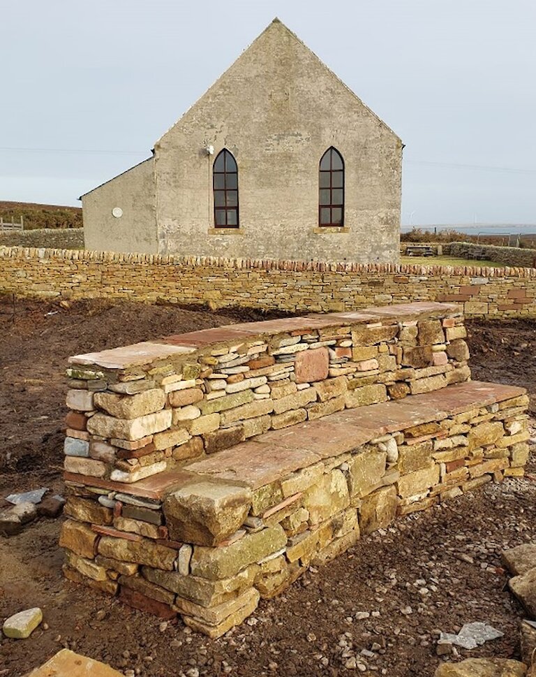 A stone bench, built with red and yellow Eday sandstone.
